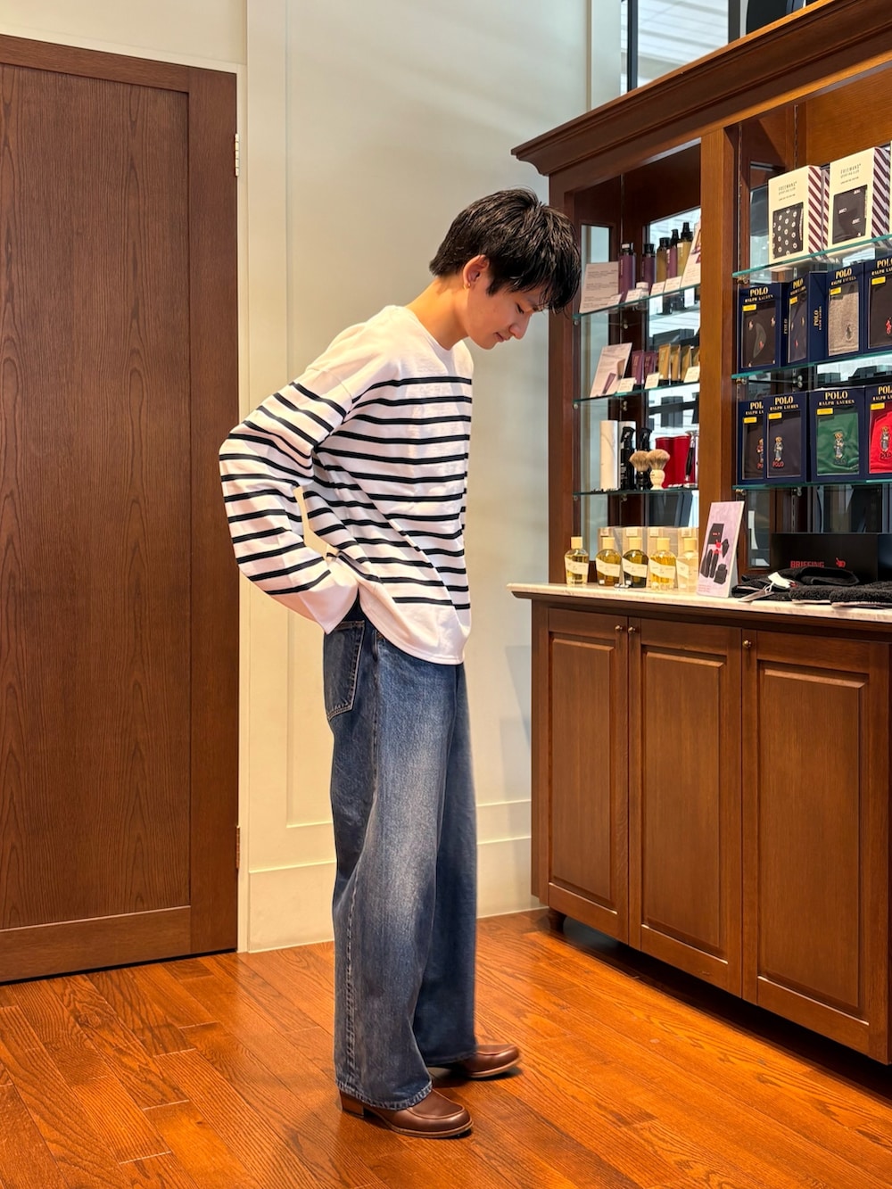 ホワイト系のTシャツ/カットソー、ブルー系のデニムパンツ、ブラウン系のローファーを着用したメンズの春コーディネートの3枚目の写真