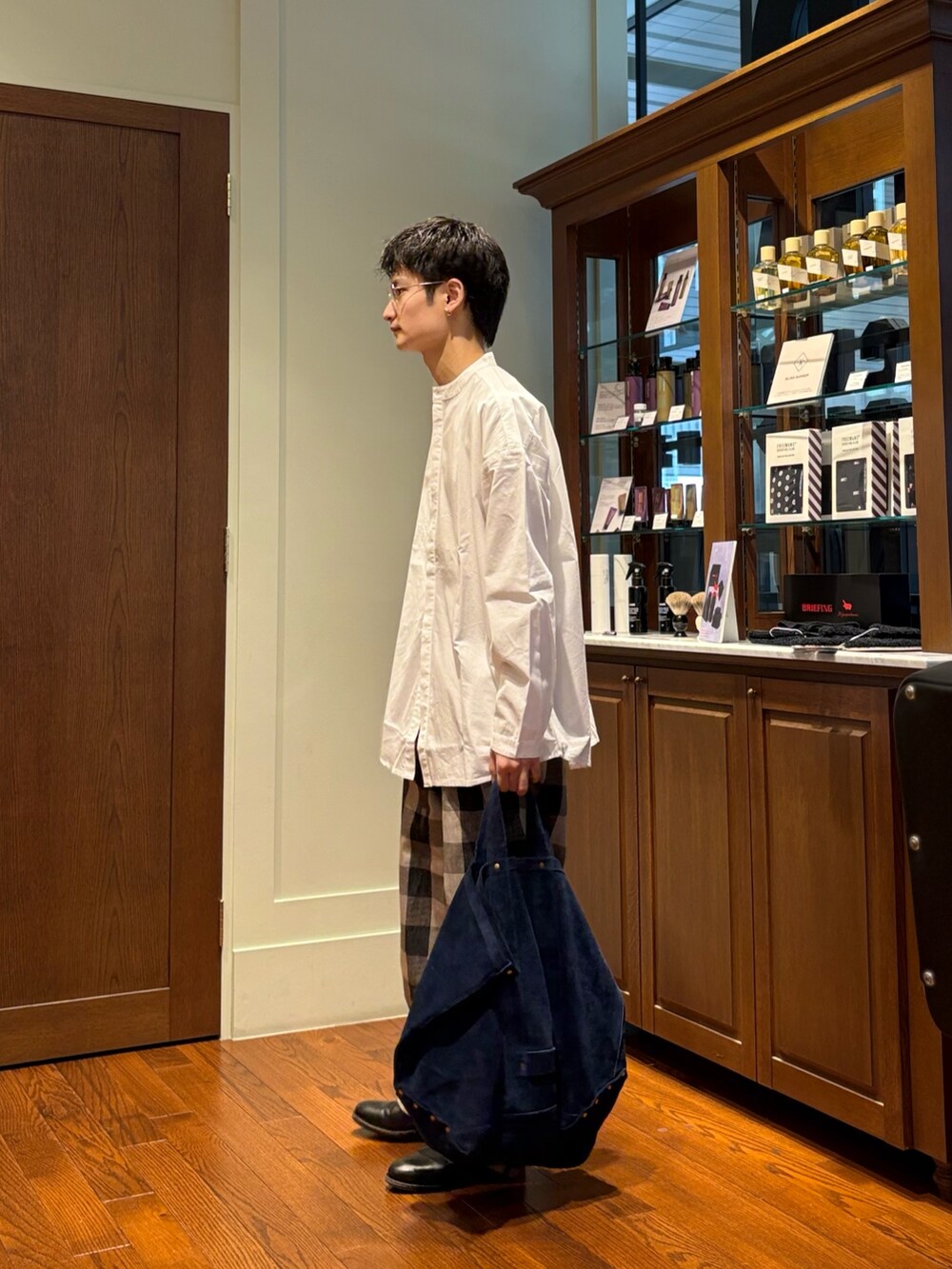 ホワイト系のシャツ/ブラウス、ホワイト系のパンツ、ブルー系のトートバッグを着用したメンズの春コーディネートの4枚目の写真