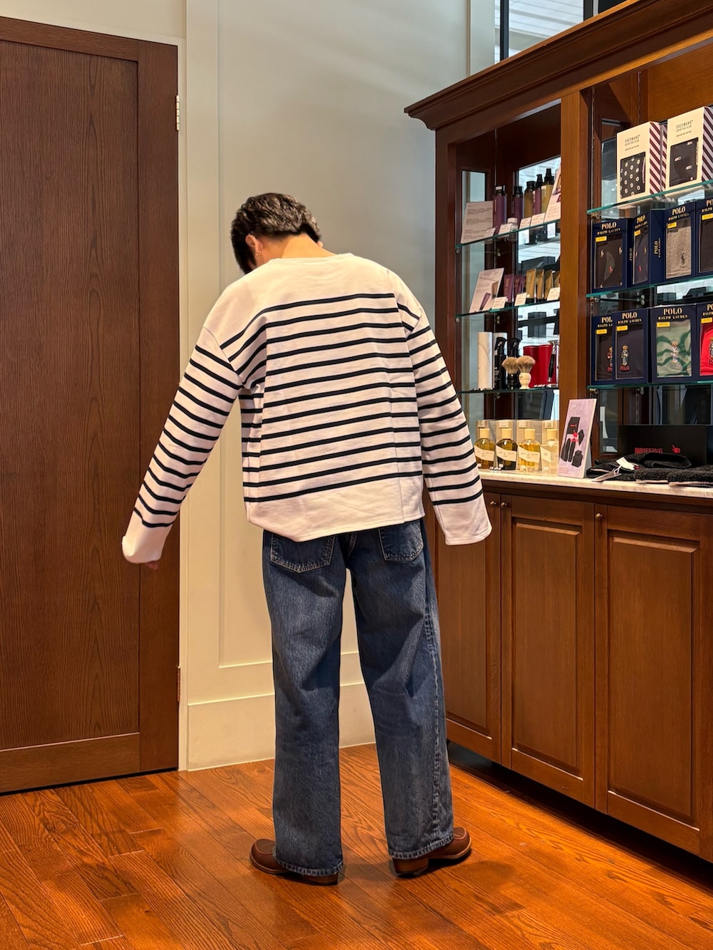 ホワイト系のTシャツ/カットソー、ブルー系のデニムパンツ、ブラウン系のローファーを着用したメンズの春コーディネートの2枚目の写真