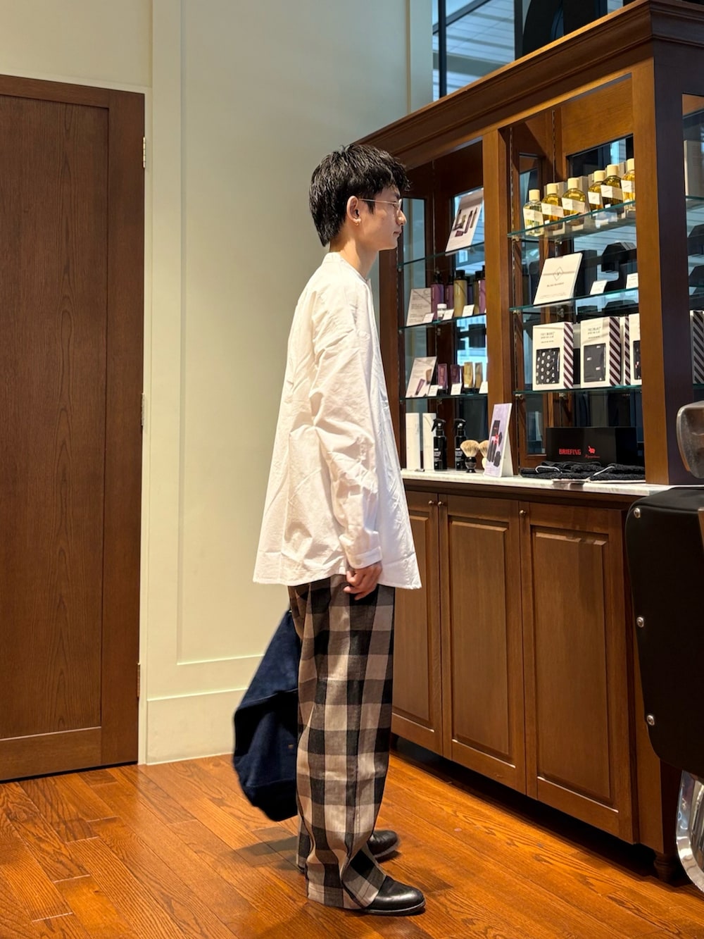 ホワイト系のシャツ/ブラウス、ホワイト系のパンツ、ブルー系のトートバッグを着用したメンズの春コーディネートの2枚目の写真