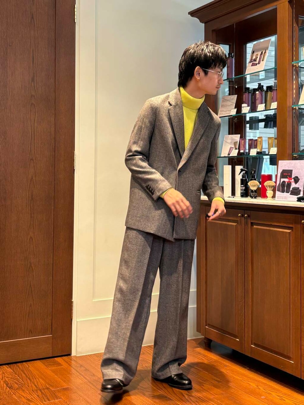 イエロー系のニット/セーター、グレー系のスラックス、グレー系のその他アウターを着用したメンズの秋コーディネートの2枚目の写真