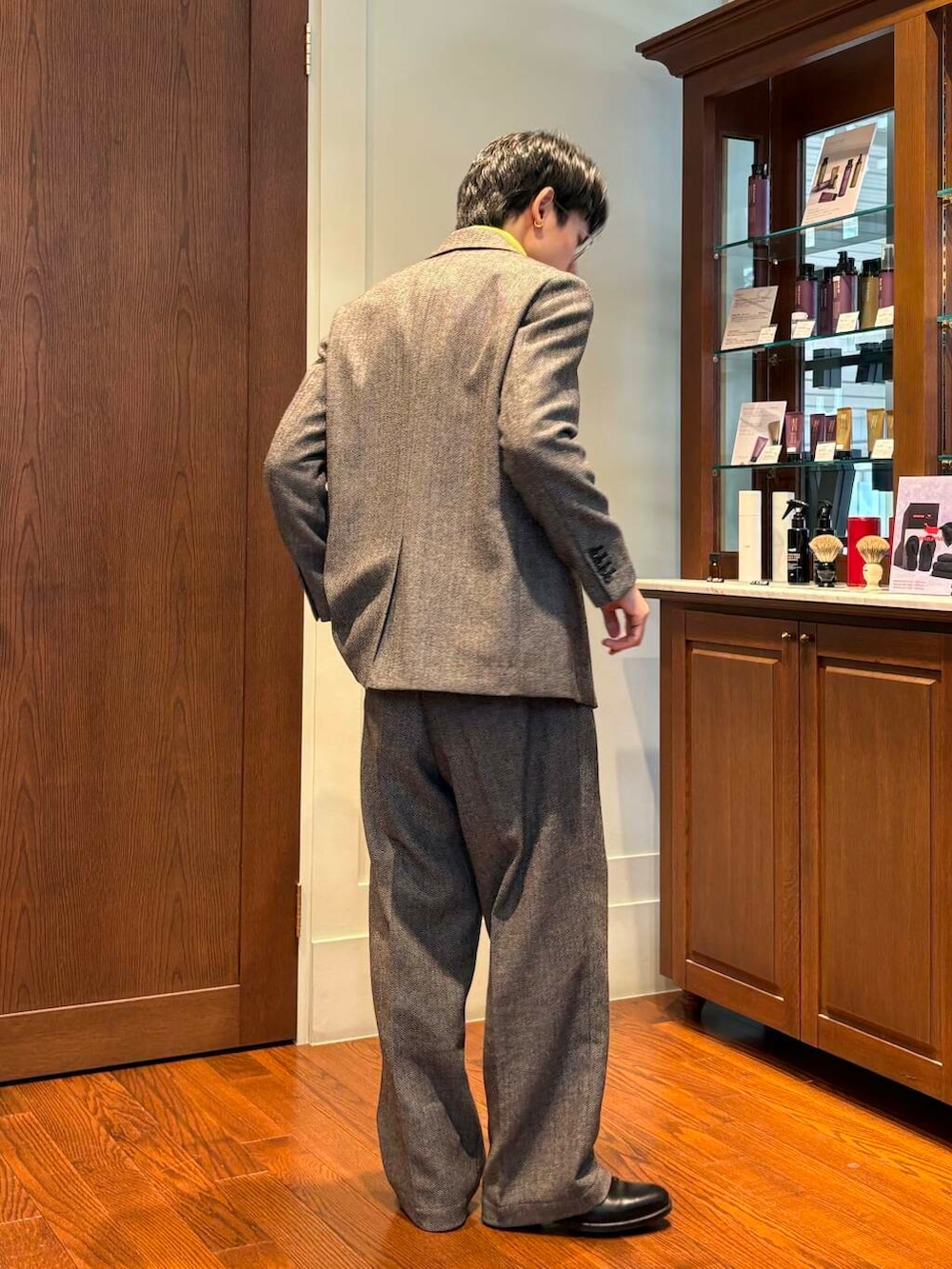 イエロー系のニット/セーター、グレー系のスラックス、グレー系のその他アウターを着用したメンズの秋コーディネートの3枚目の写真