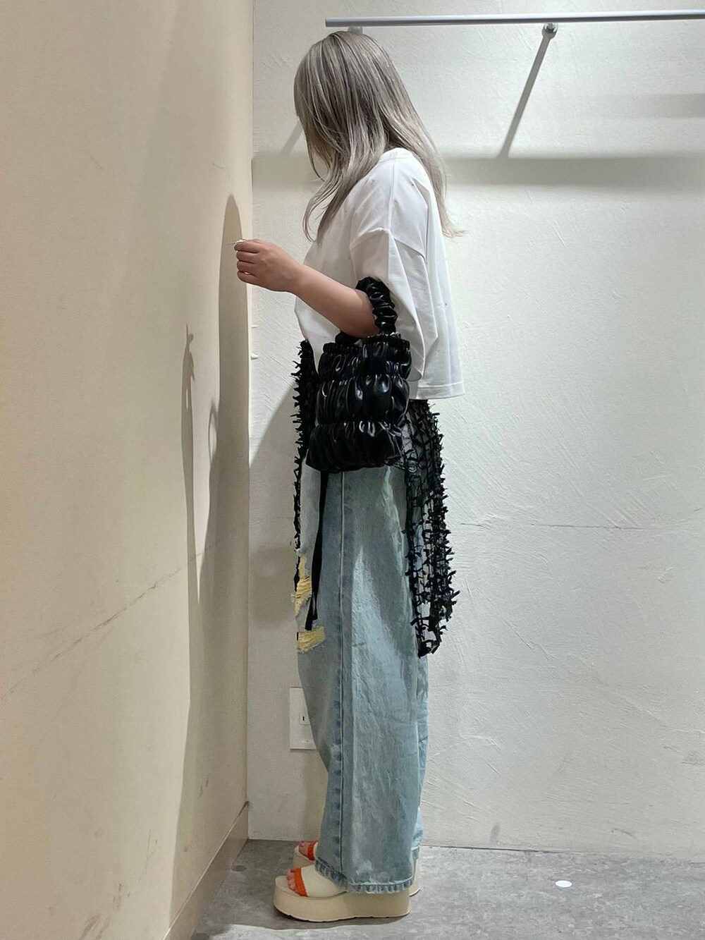 ベージュ系のサンダル、ブルー系のデニムパンツ、ブラック系のショルダーバッグを着用したレディースの夏コーディネートの4枚目の写真