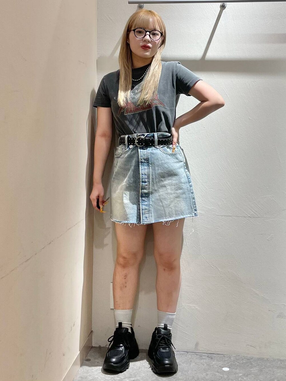 ブラック系のスニーカー、ブルー系のデニムスカート、グレー系のTシャツ/カットソーを着用したレディースの夏コーディネートの5枚目の写真