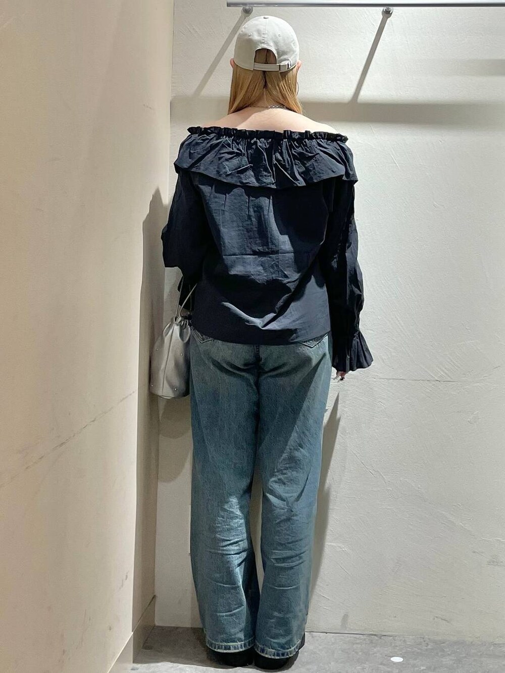 シルバー系のショルダーバッグ、グレー系のシャツ/ブラウス、シルバー系のスニーカーを着用したレディースの春コーディネートの3枚目の写真