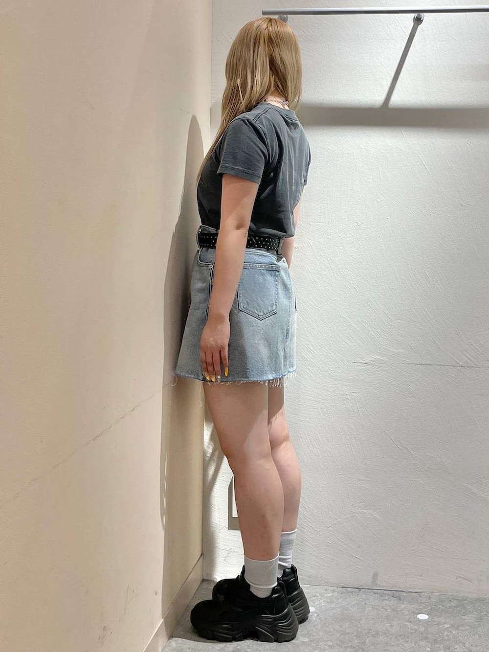 ブラック系のスニーカー、ブルー系のデニムスカート、グレー系のTシャツ/カットソーを着用したレディースの夏コーディネートの4枚目の写真