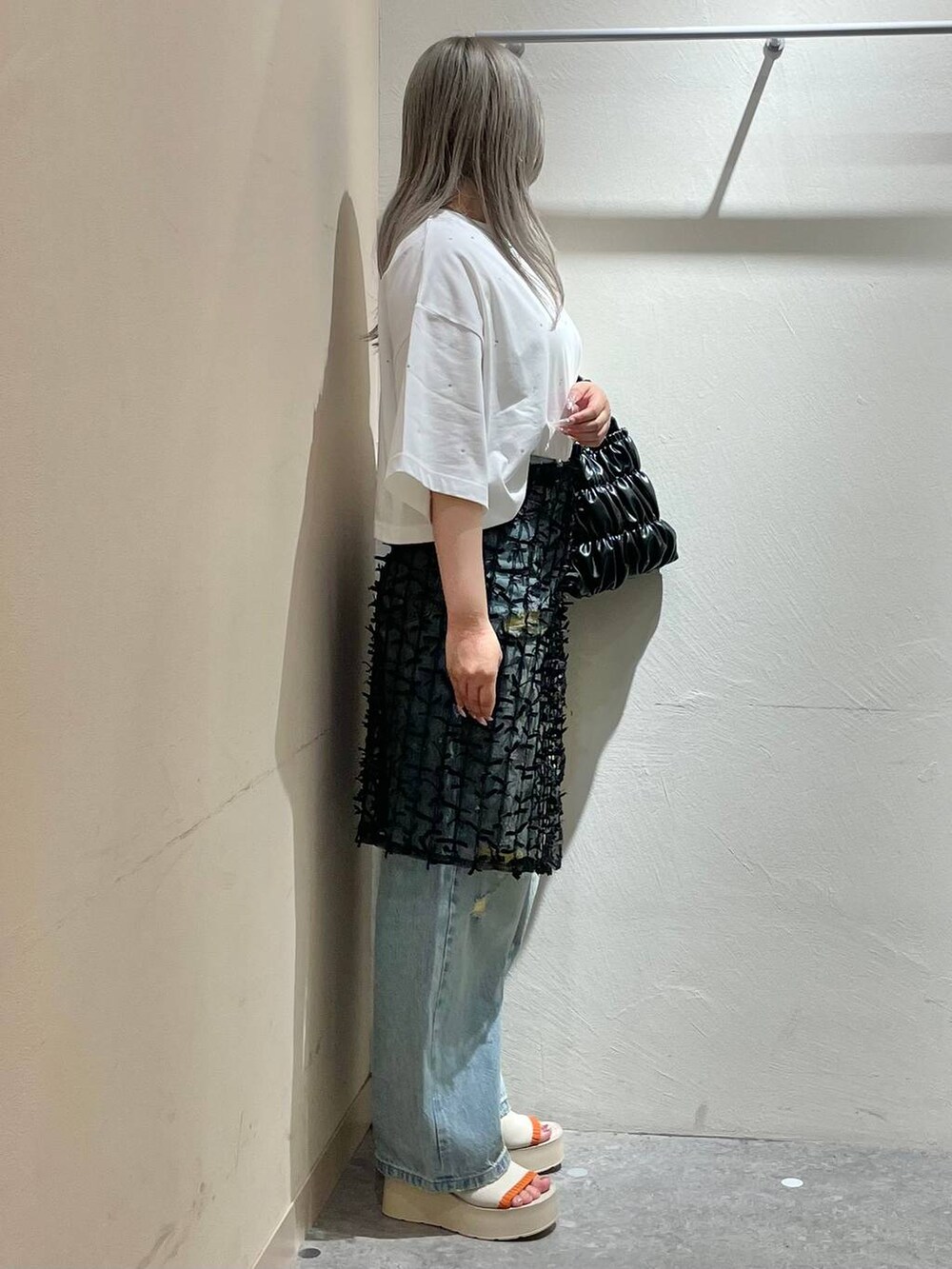 ベージュ系のサンダル、ブルー系のデニムパンツ、ブラック系のショルダーバッグを着用したレディースの夏コーディネートの2枚目の写真