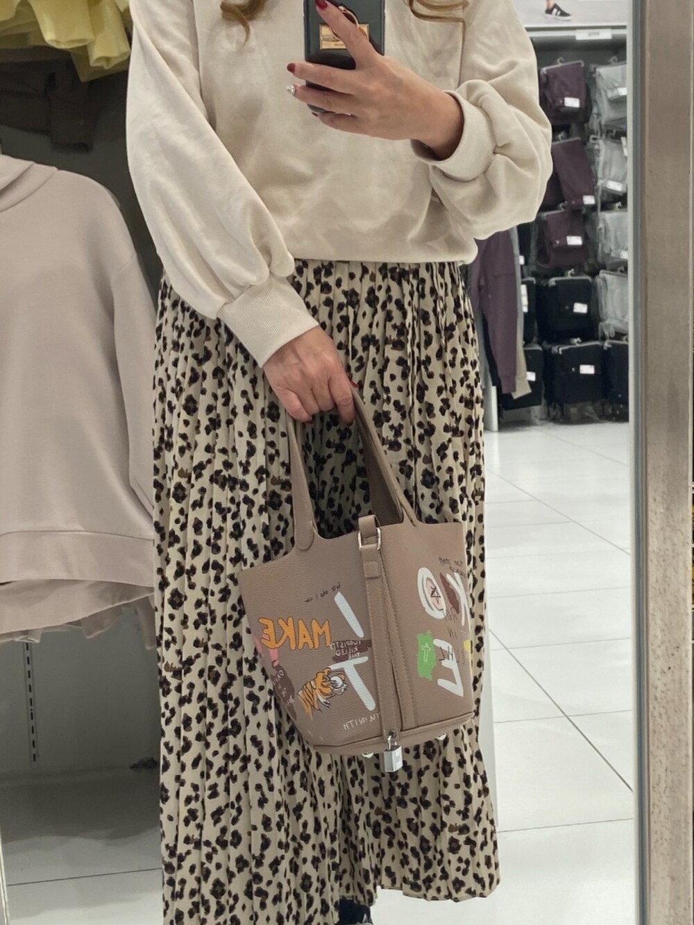 ブラック系のスニーカー、ベージュ系のTシャツ/カットソーを着用したレディースの秋コーディネートの2枚目の写真