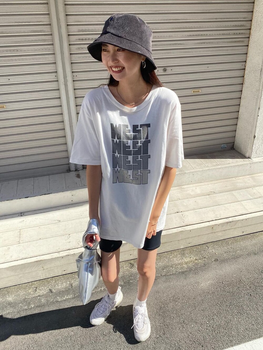 ホワイト系のTシャツ/カットソー、シルバー系のトートバッグ、ホワイト系のスニーカーを着用したレディースの夏コーディネートの4枚目の写真