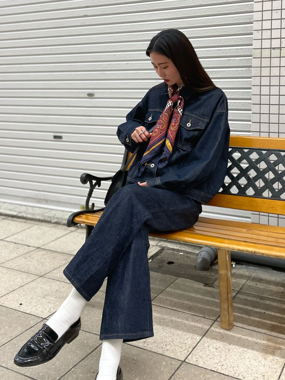 ブルー系のデニムパンツ、ブルー系のデニムジャケット、ピンク系のバンダナ/スカーフを着用したレディースの春コーディネートの2枚目の写真