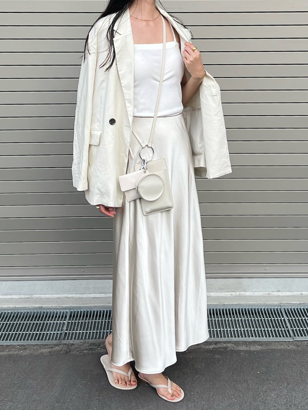 ホワイト系のビーチサンダル、ホワイト系のスカート、ホワイト系のキャミソールを着用したレディースの夏コーディネートの2枚目の写真