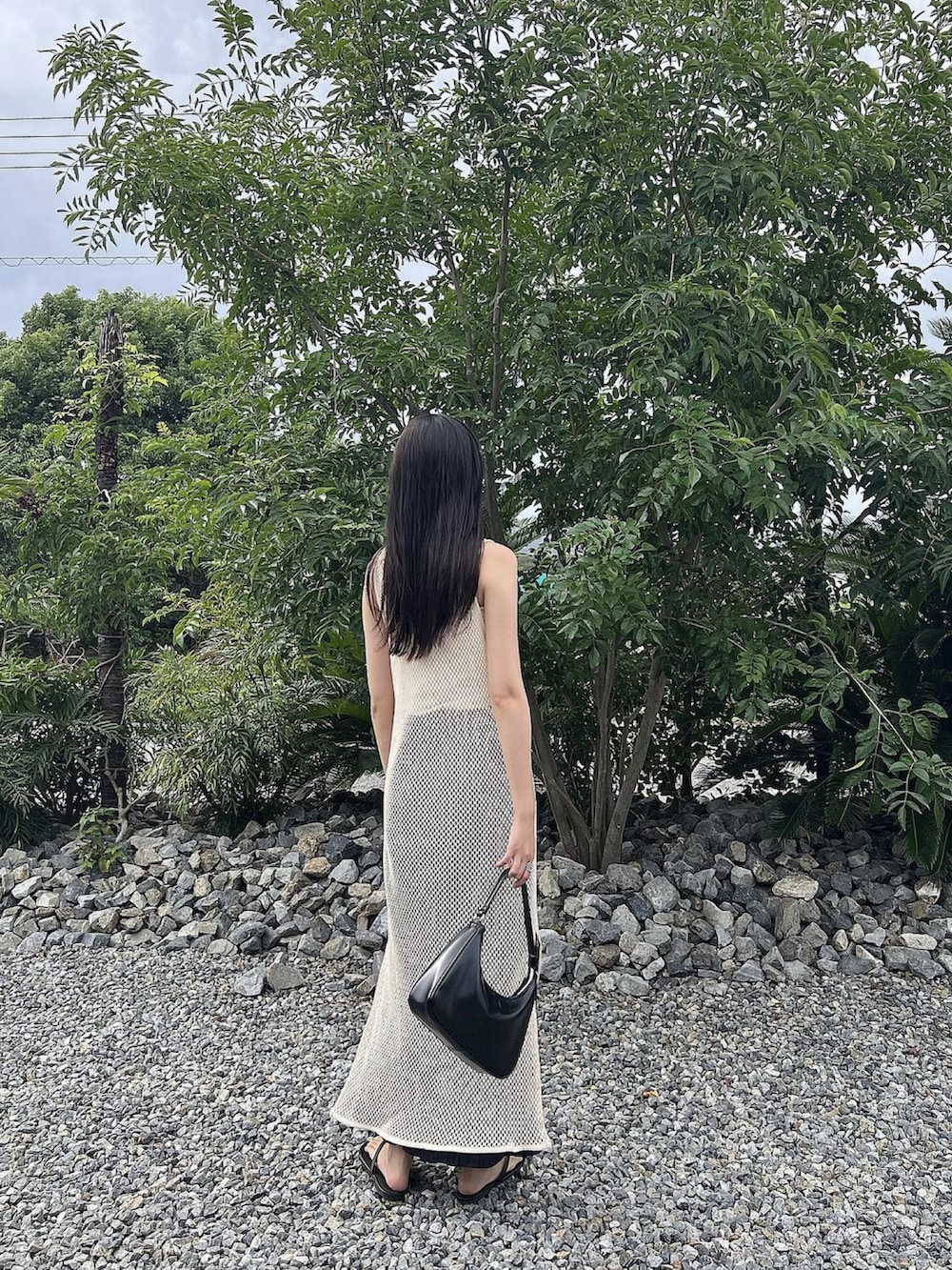 ホワイト系のワンピース/ドレス、ブラック系のバッグ、ブラック系のビーチサンダルを着用したレディースの秋コーディネートの3枚目の写真