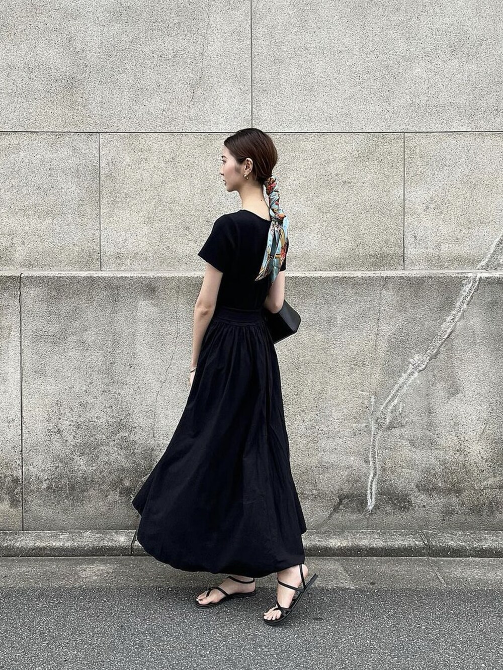 ブラック系のサンダル、ブラック系のワンピース、ブラック系のバッグを着用したレディースの夏コーディネートの2枚目の写真