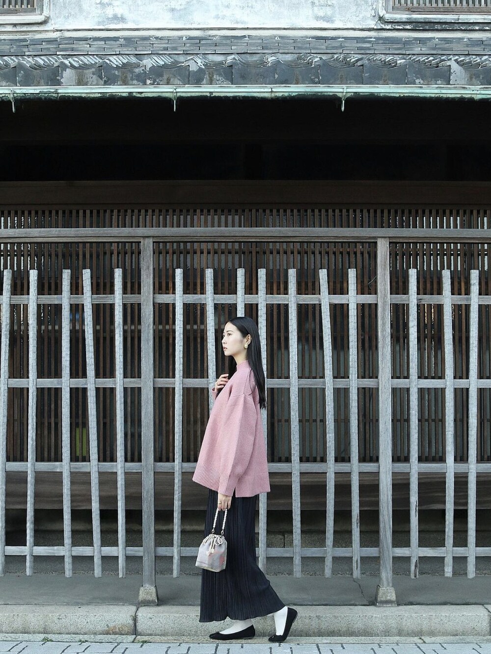 ピンク系のニット/セーター、ブラック系のスカート、ブラック系のバレエシューズを着用したレディースの冬コーディネートの2枚目の写真