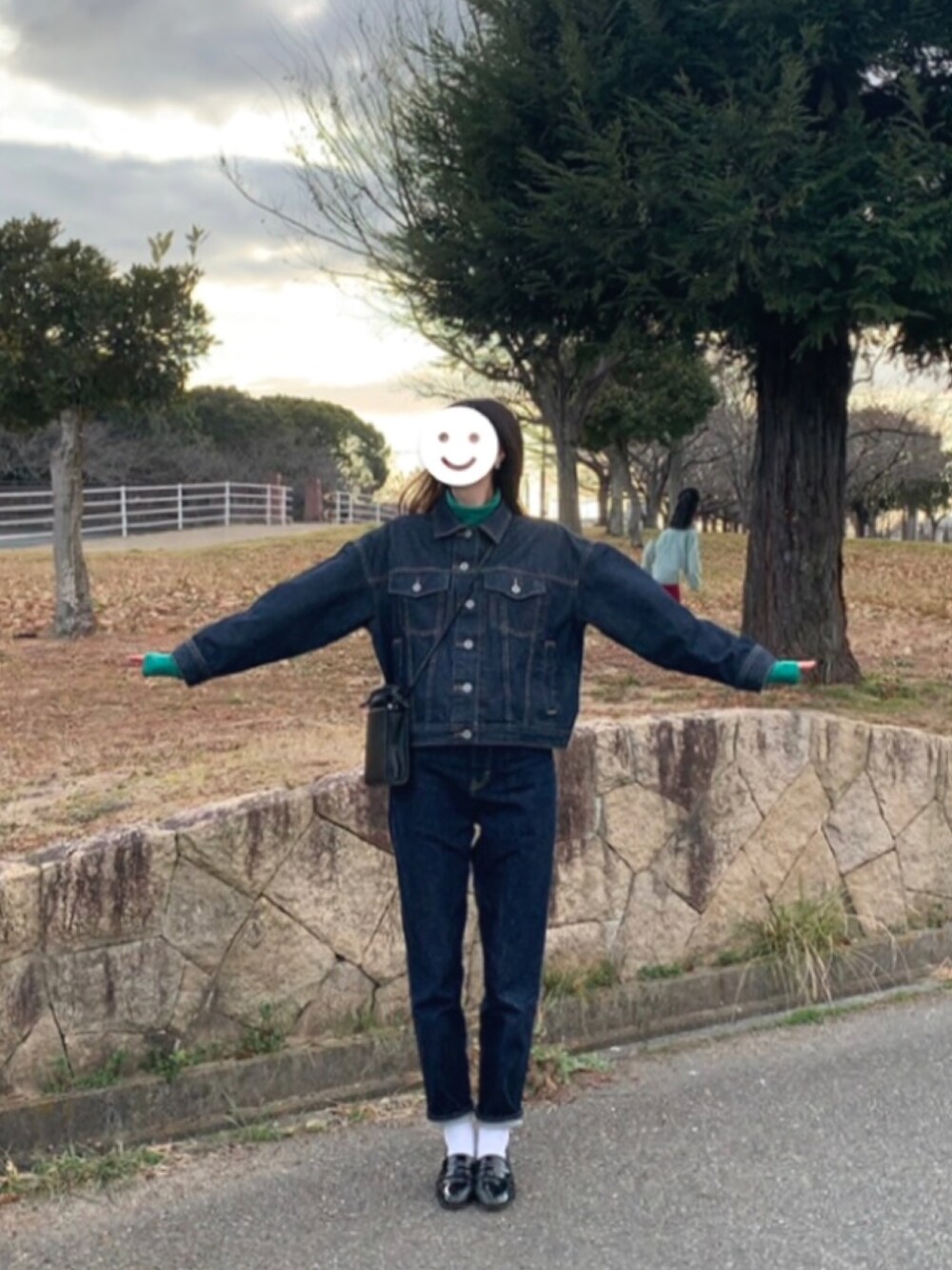 ブルー系のデニムパンツ、ブラック系のショルダーバッグ、ブルー系のデニムジャケットを着用したレディースの春コーディネートの2枚目の写真
