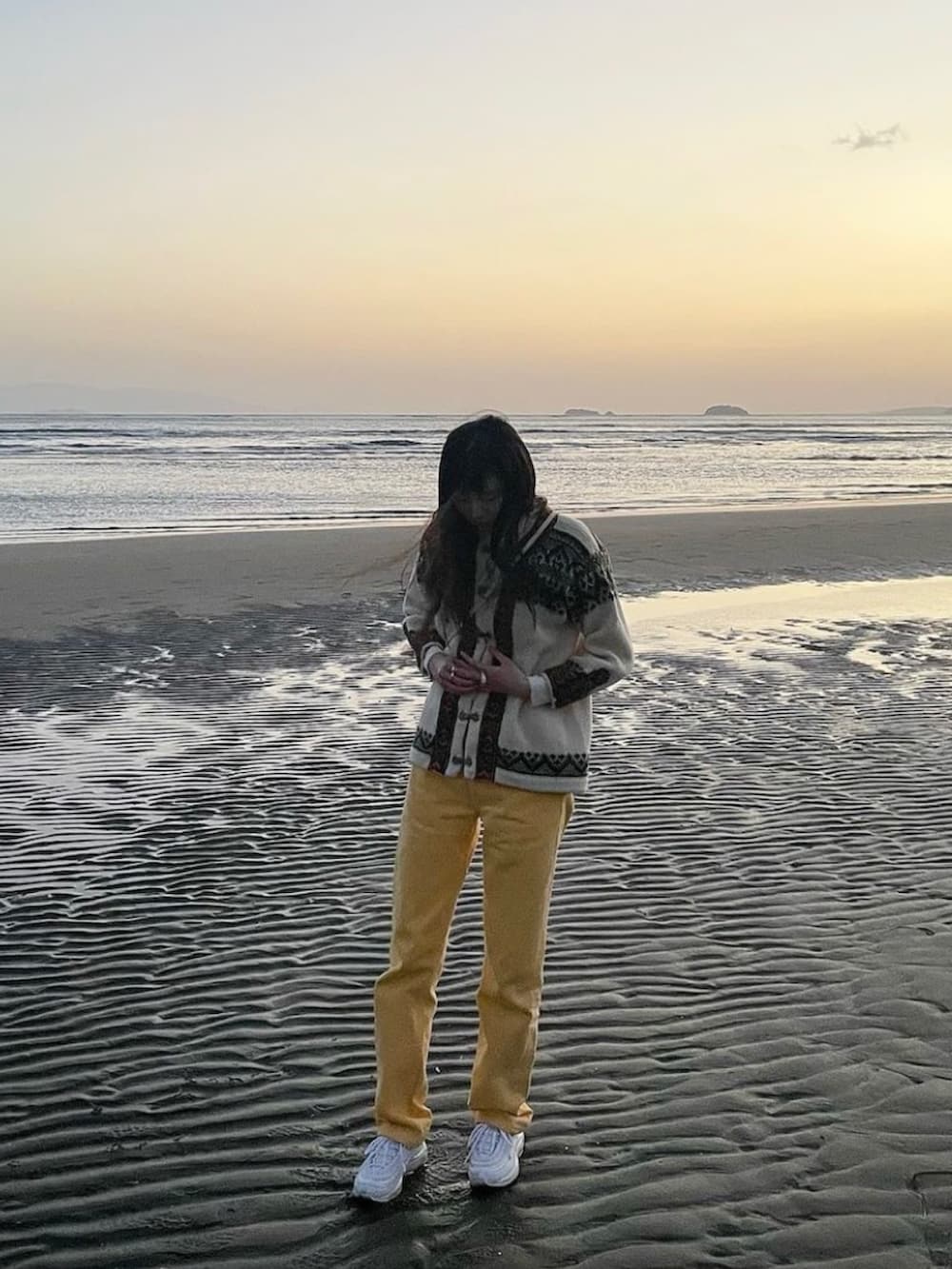 イエロー系のデニムパンツ、ホワイト系のスニーカー、ホワイト系のショルダーバッグを着用したレディースの春コーディネートの3枚目の写真