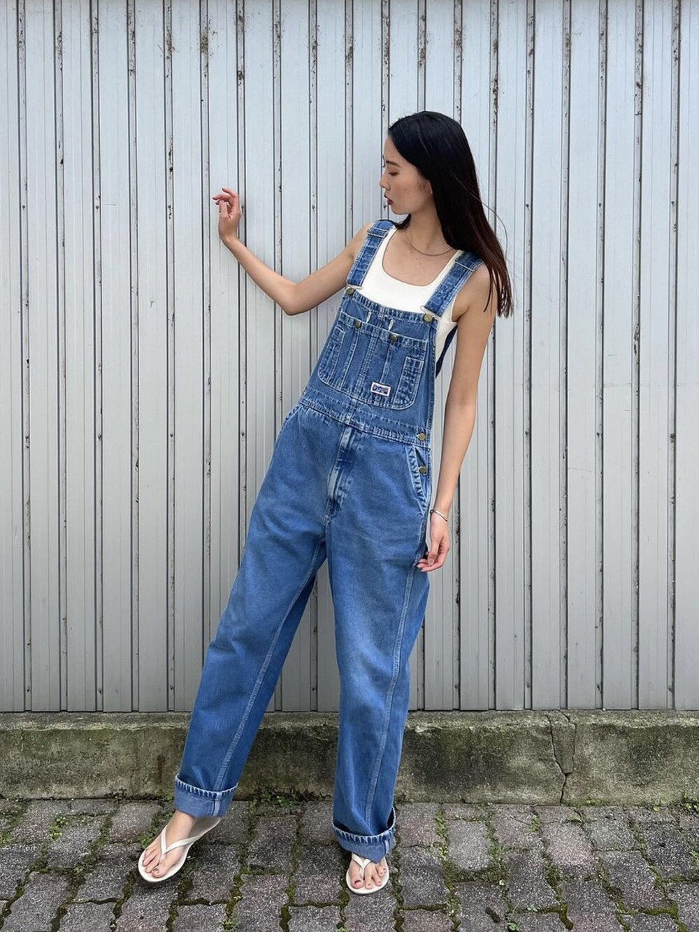 ホワイト系のビーチサンダル、ブルー系のサロペット/オーバーオール、ホワイト系のタンクトップを着用したレディースの夏コーディネートの2枚目の写真