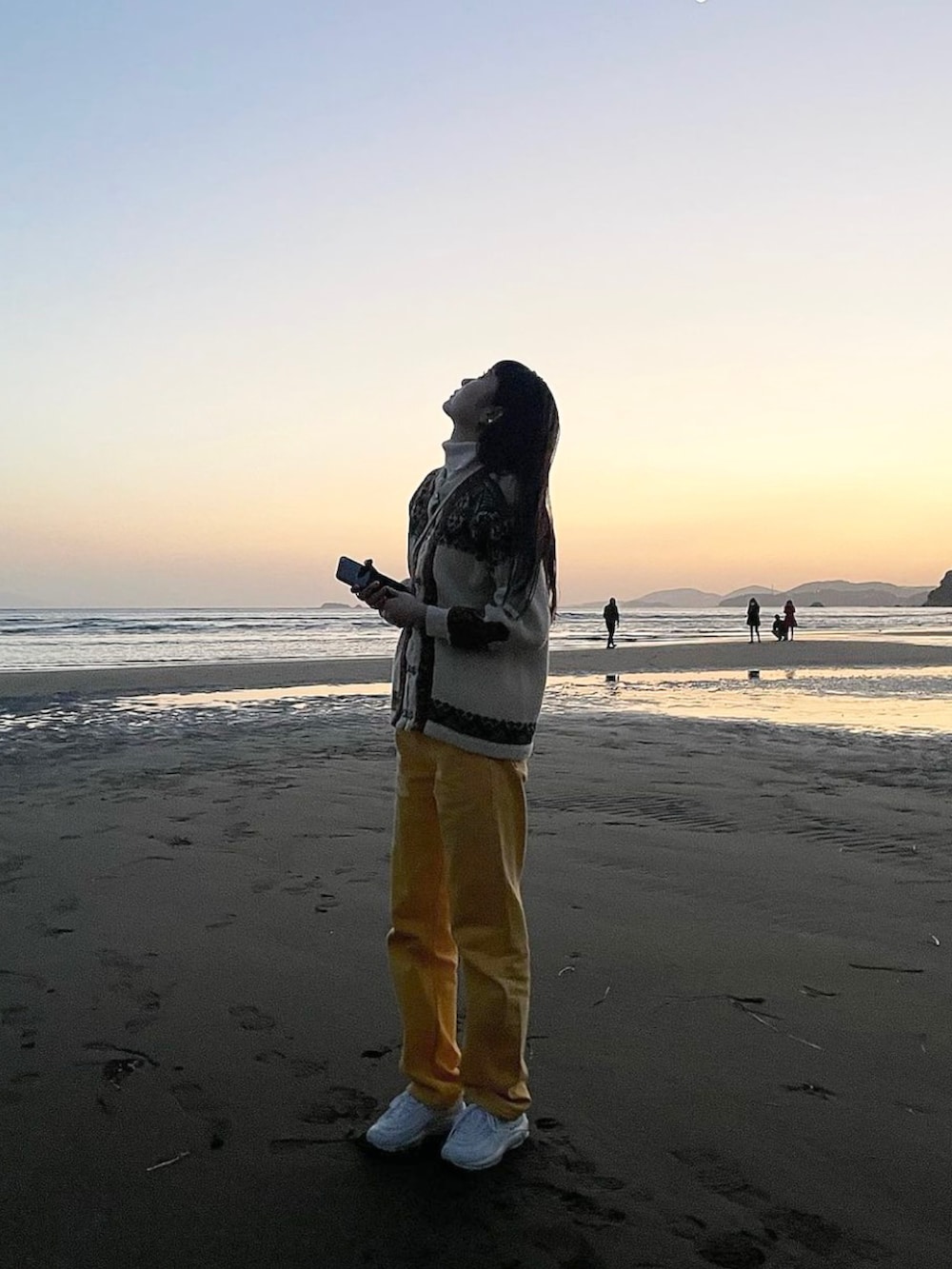 イエロー系のデニムパンツ、ホワイト系のスニーカー、ホワイト系のショルダーバッグを着用したレディースの春コーディネートの2枚目の写真