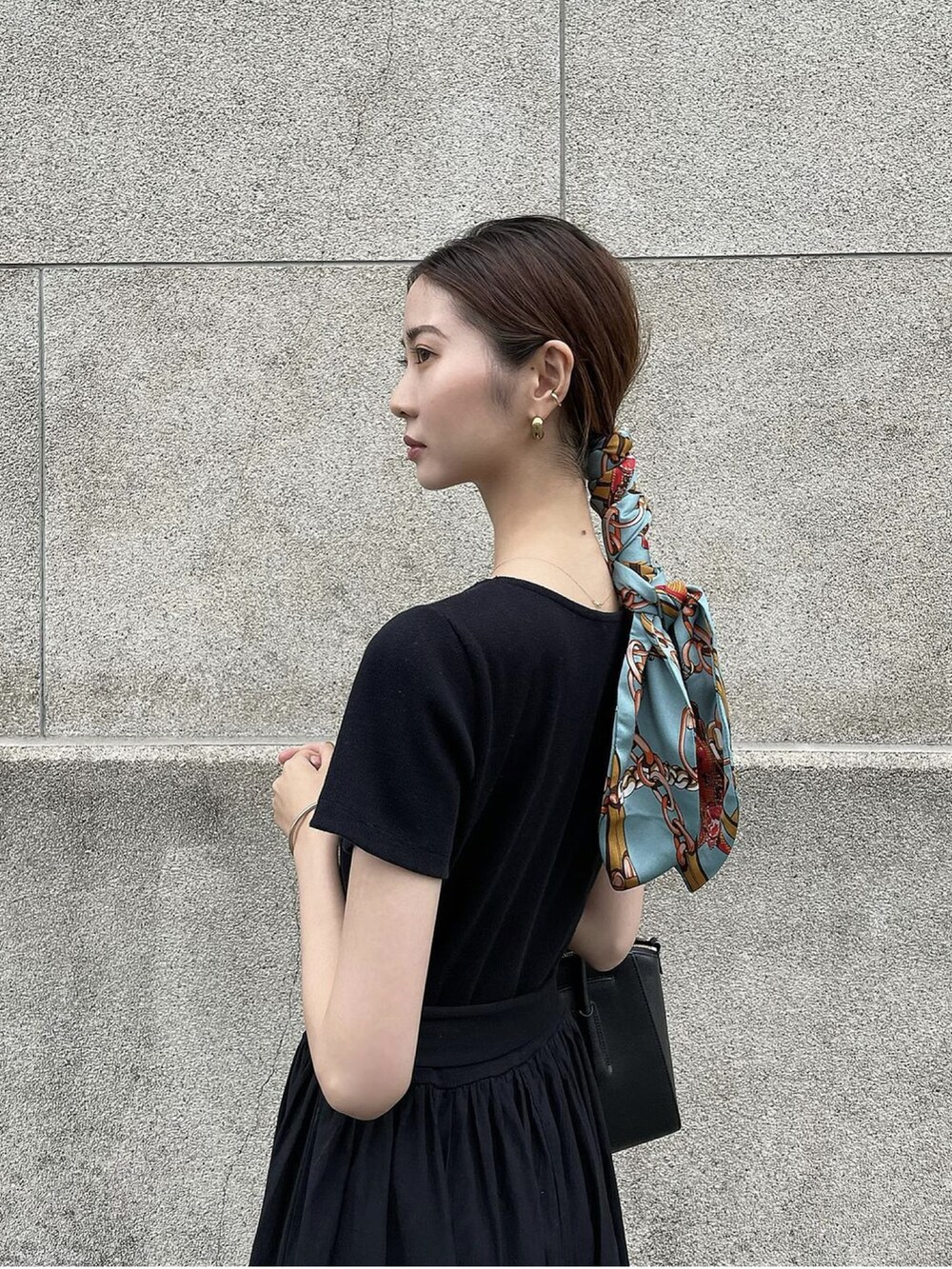 ブラック系のサンダル、ブラック系のワンピース、ブラック系のバッグを着用したレディースの夏コーディネートの3枚目の写真