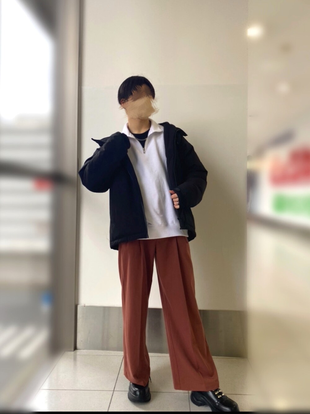 ブラック系のスニーカー、ブラウン系のパンツ、ブラック系のダウンジャケット/コートを着用したメンズの冬コーディネートの3枚目の写真