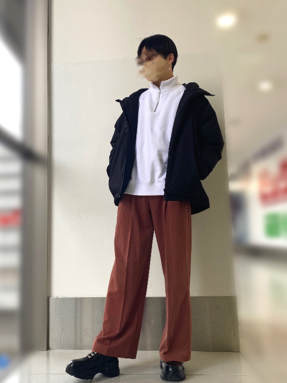 ブラック系のスニーカー、ブラウン系のパンツ、ブラック系のダウンジャケット/コートを着用したメンズの冬コーディネートの2枚目の写真