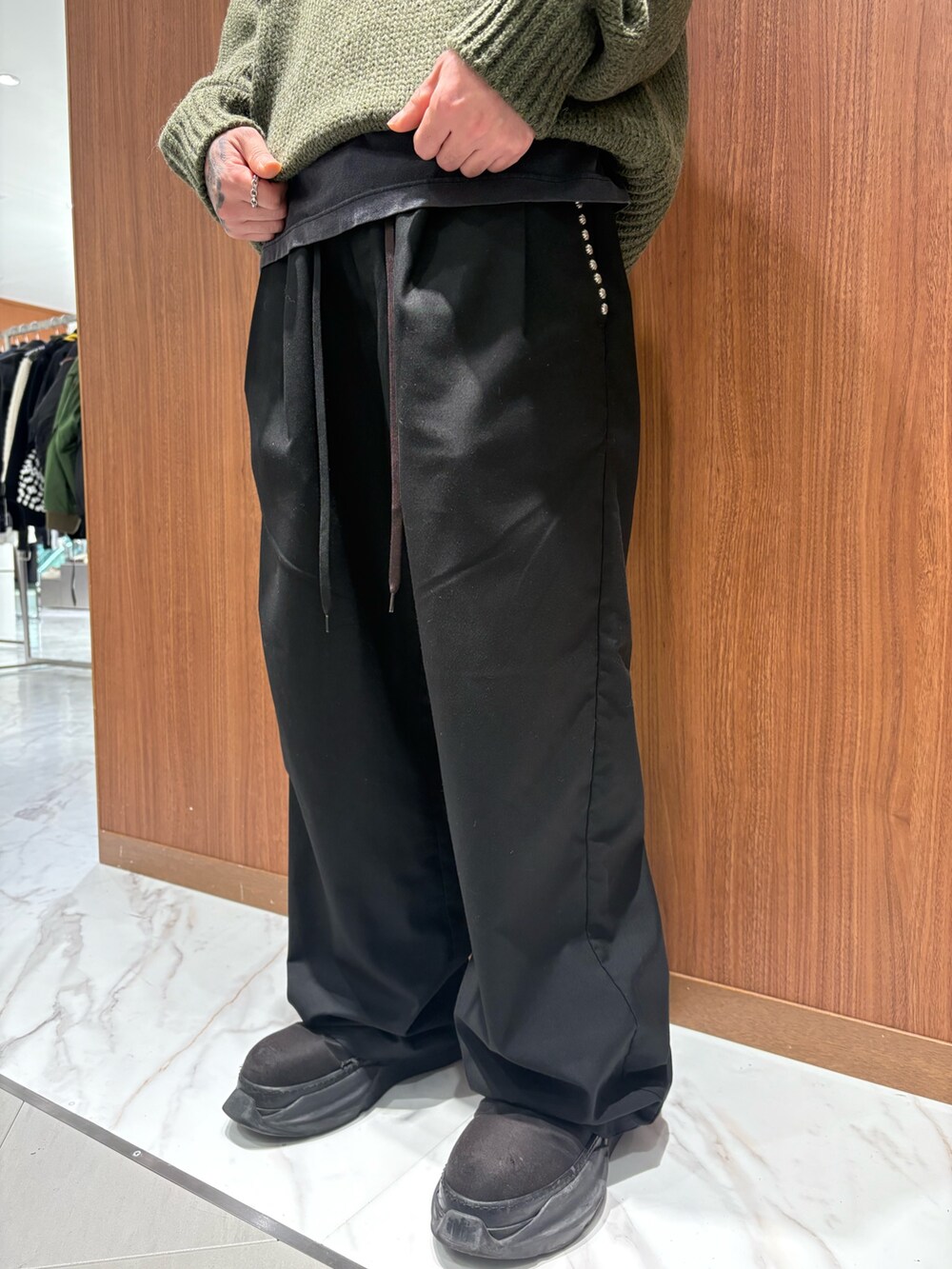 ブラック系のチノパンツ、グリーン系のニット/セーターを着用したメンズの冬コーディネートの2枚目の写真