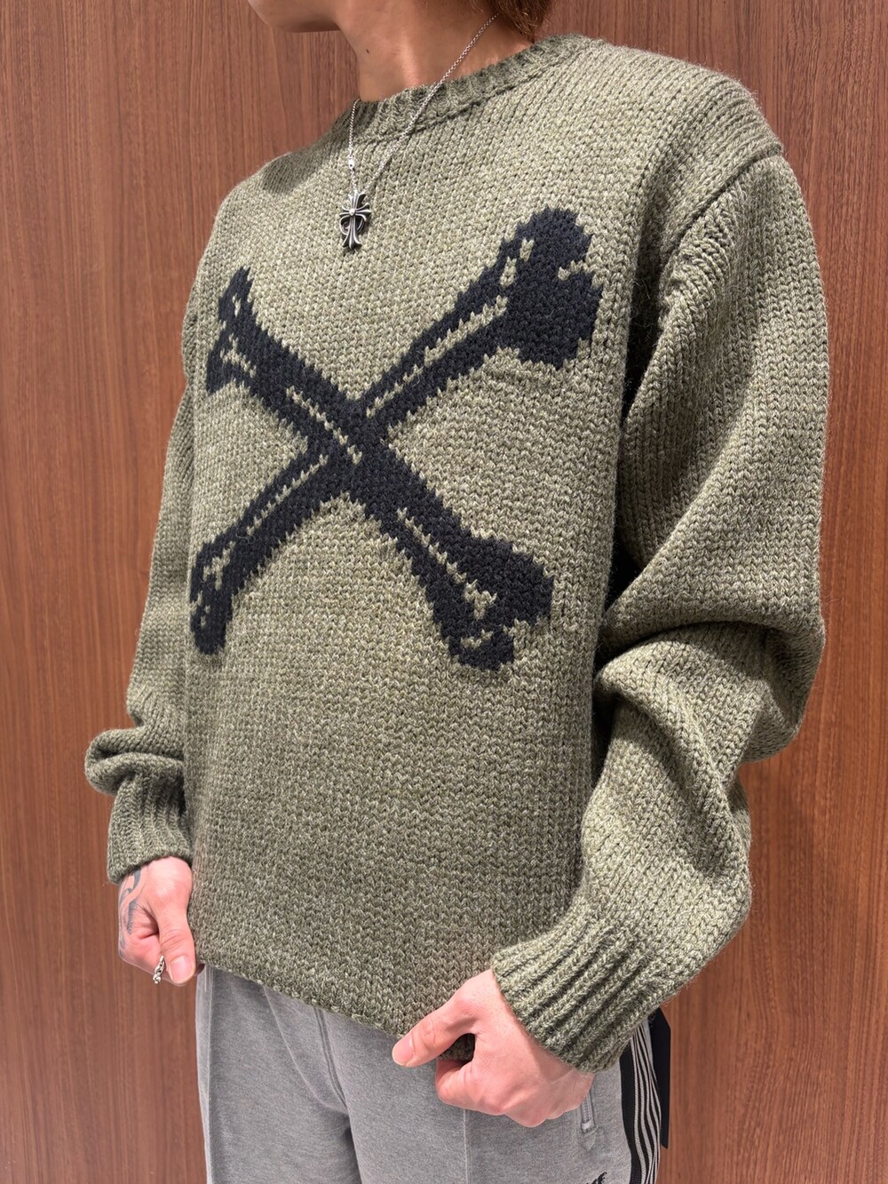 グリーン系のニット/セーター、グレー系のスウェットパンツを着用したメンズの冬コーディネートの2枚目の写真