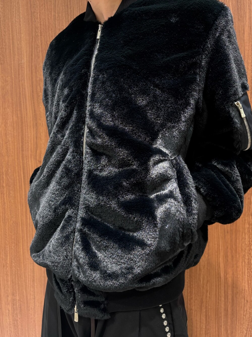 ブラック系のその他アウター、ブラック系のチノパンツを着用したメンズの冬コーディネートの2枚目の写真