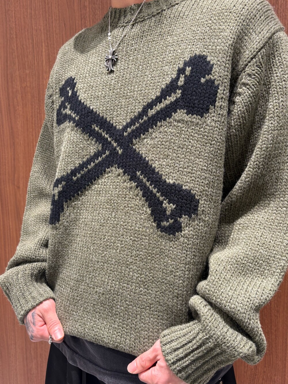 ブラック系のチノパンツ、グリーン系のニット/セーターを着用したメンズの冬コーディネートの3枚目の写真