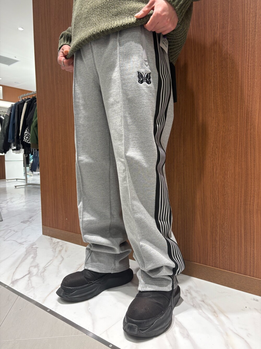 グリーン系のニット/セーター、グレー系のスウェットパンツを着用したメンズの冬コーディネートの3枚目の写真