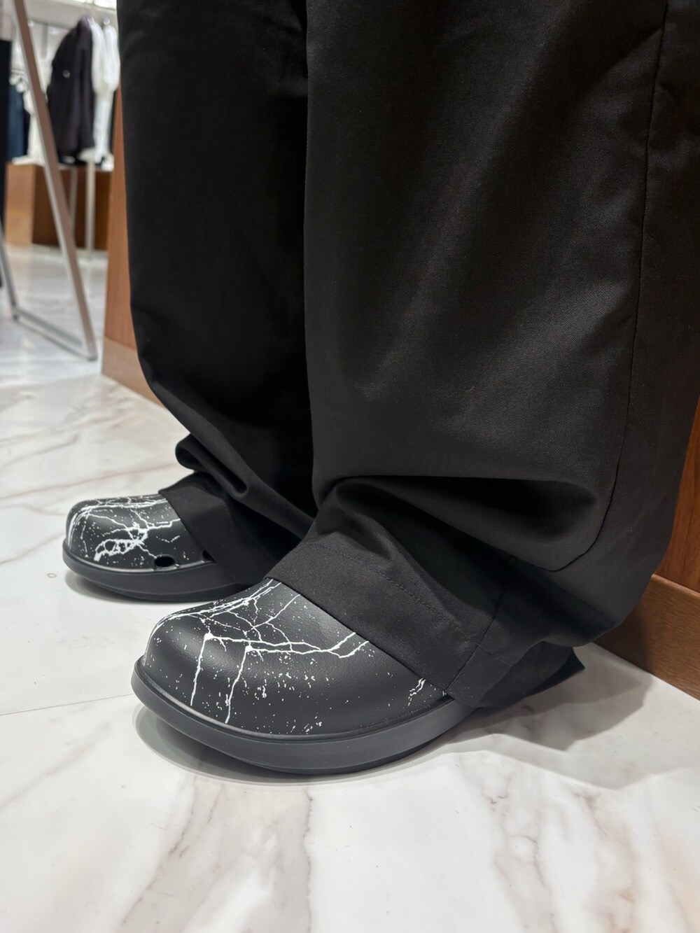 ブラック系のサンダル、ブラック系のチノパンツを着用したメンズの秋コーディネートの3枚目の写真