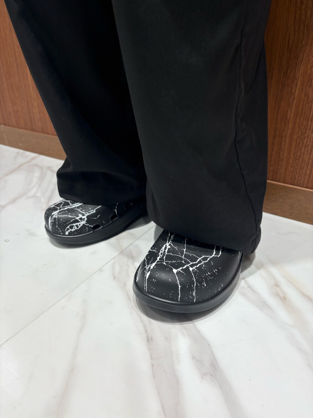 ブラック系のチノパンツ、ブラック系のサンダルを着用したメンズの秋コーディネートの3枚目の写真