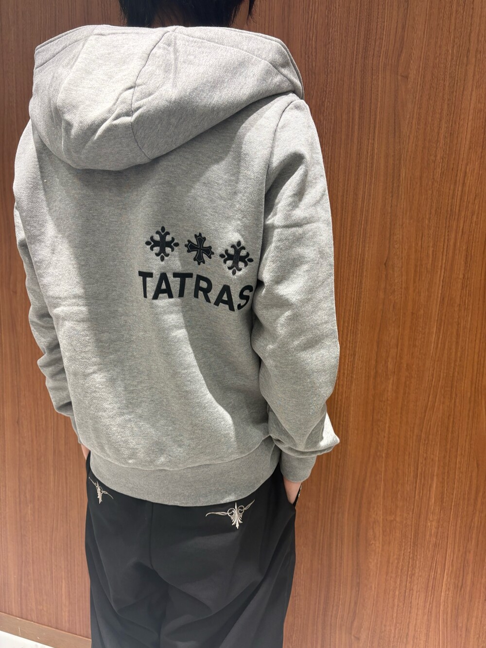 グレー系のパーカー、ブラック系のチノパンツを着用したメンズの秋コーディネートの3枚目の写真