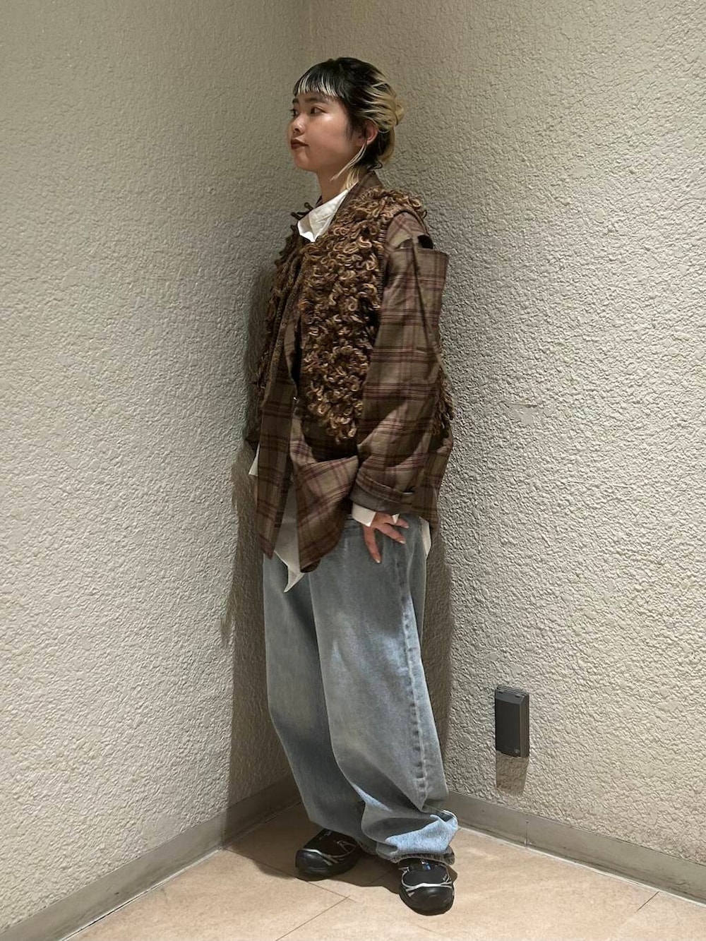 ブルー系のデニムパンツ、ブラウン系のベスト、ホワイト系のワンピースを着用したレディースの夏コーディネートの5枚目の写真