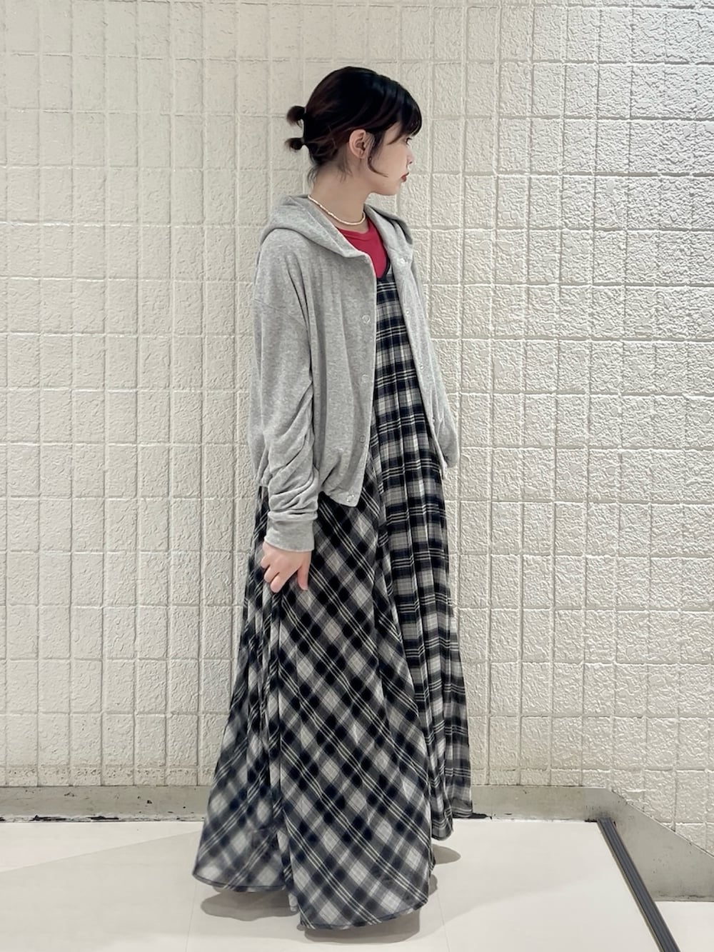 グレー系のパーカー、レッド系のタンクトップ、ブラック系のワンピースを着用したレディースの春コーディネートの2枚目の写真