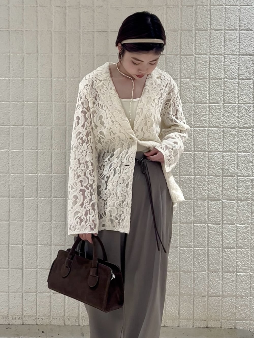 ホワイト系のキャミソール、グレー系のその他パンツ、ブラウン系のボストンバッグを着用したレディースの冬コーディネートの5枚目の写真