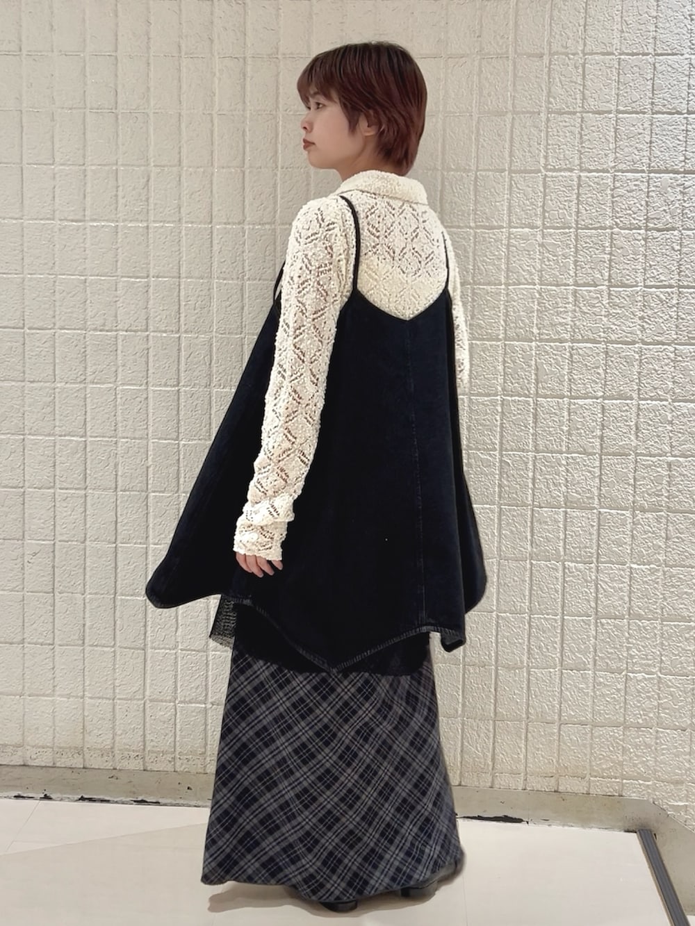 ホワイト系のニット/セーター、ブラック系のワンピース、ブルー系のスカートを着用したレディースの冬コーディネートの4枚目の写真