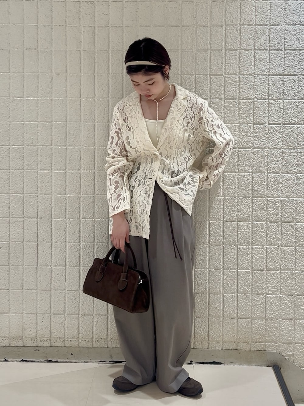 ホワイト系のキャミソール、グレー系のその他パンツ、ブラウン系のボストンバッグを着用したレディースの冬コーディネートの2枚目の写真