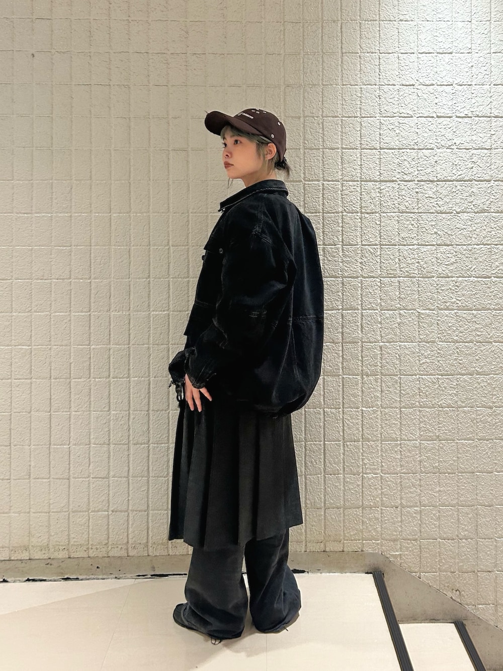 ブラック系のデニムパンツ、グレー系のスカート、ブラック系のカバーオールを着用したレディースの秋コーディネートの2枚目の写真
