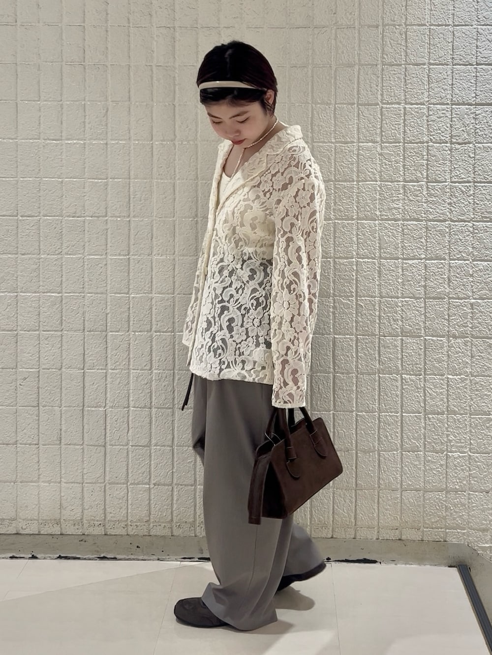 ホワイト系のキャミソール、グレー系のその他パンツ、ブラウン系のボストンバッグを着用したレディースの冬コーディネートの4枚目の写真