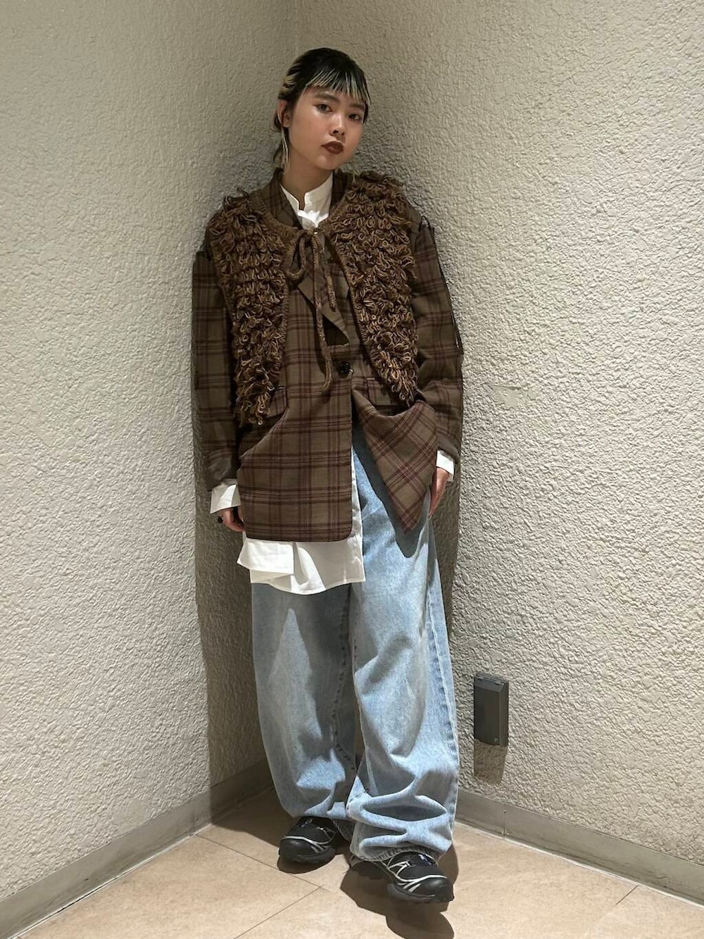 ブルー系のデニムパンツ、ブラウン系のベスト、ホワイト系のワンピースを着用したレディースの夏コーディネートの3枚目の写真