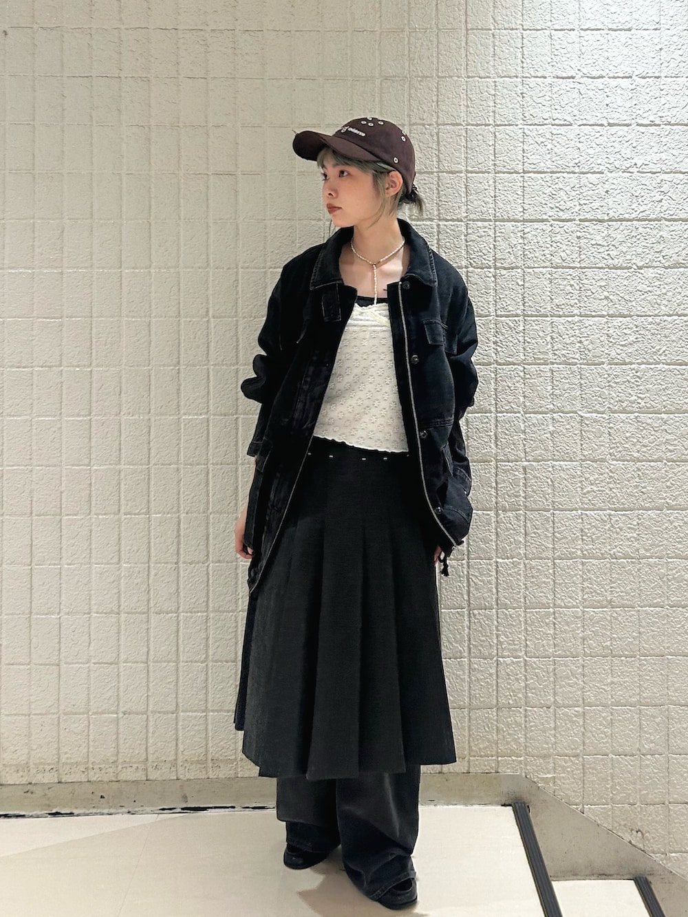 ブラック系のデニムパンツ、グレー系のスカート、ブラック系のカバーオールを着用したレディースの秋コーディネートの5枚目の写真