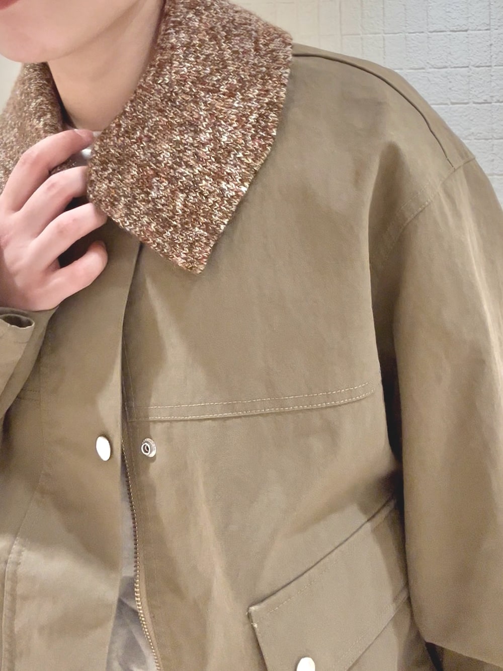 グリーン系のブルゾン、ブラウン系のスカート、ベージュ系のハンドバッグを着用したレディースの冬コーディネートの5枚目の写真