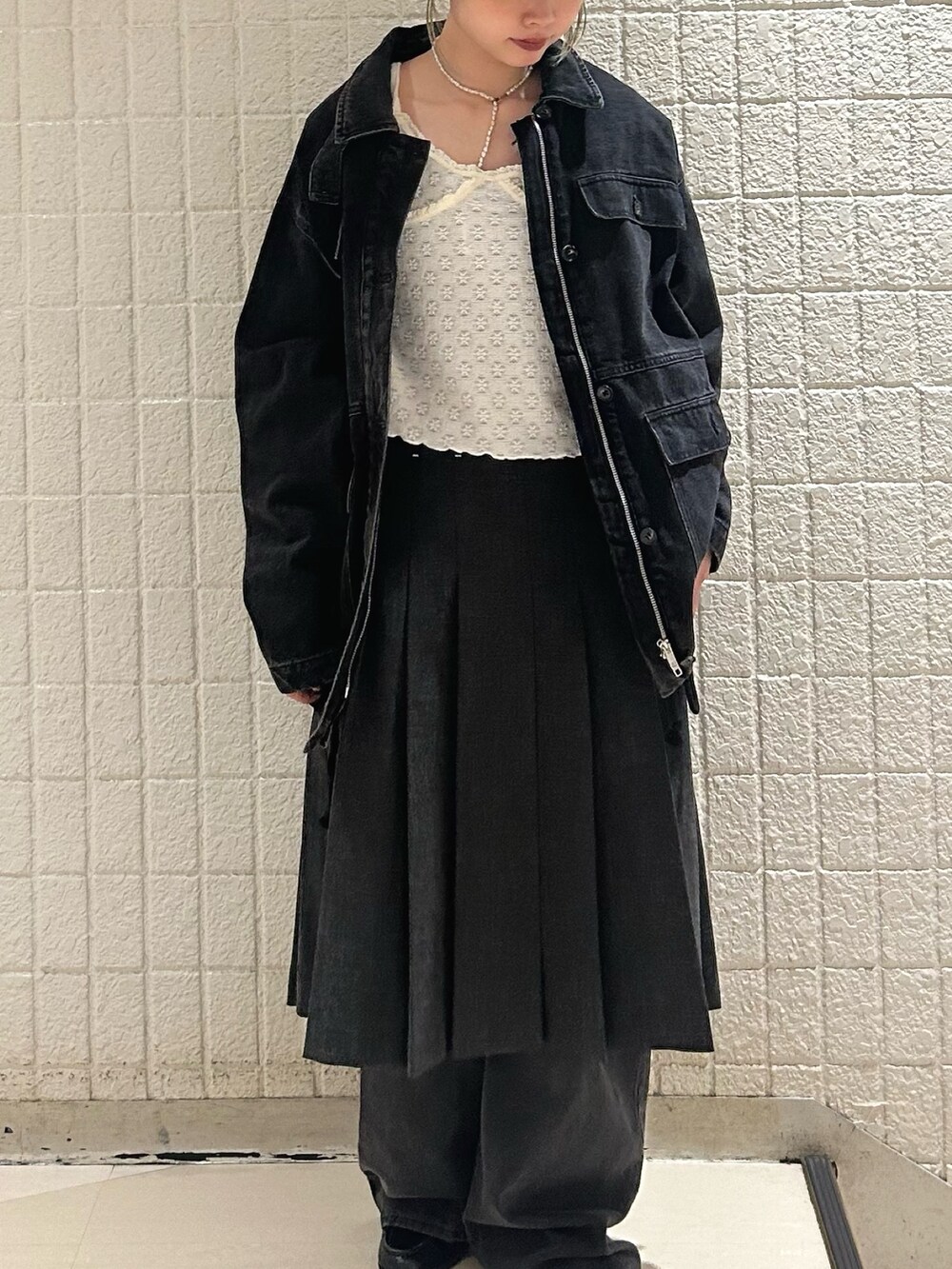 ブラック系のデニムパンツ、グレー系のスカート、ブラック系のカバーオールを着用したレディースの秋コーディネートの4枚目の写真