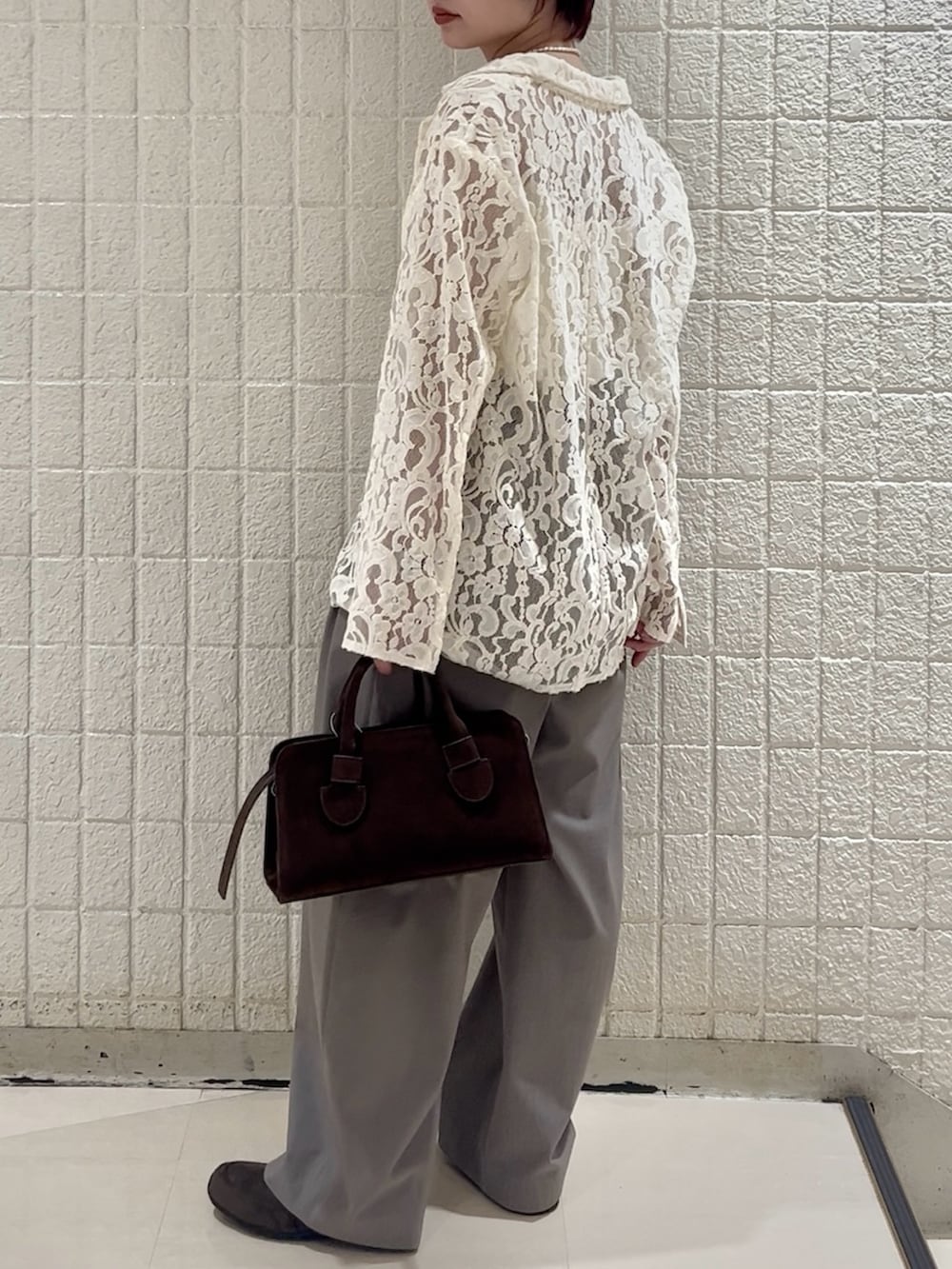 ホワイト系のキャミソール、グレー系のその他パンツ、ブラウン系のボストンバッグを着用したレディースの冬コーディネートの3枚目の写真