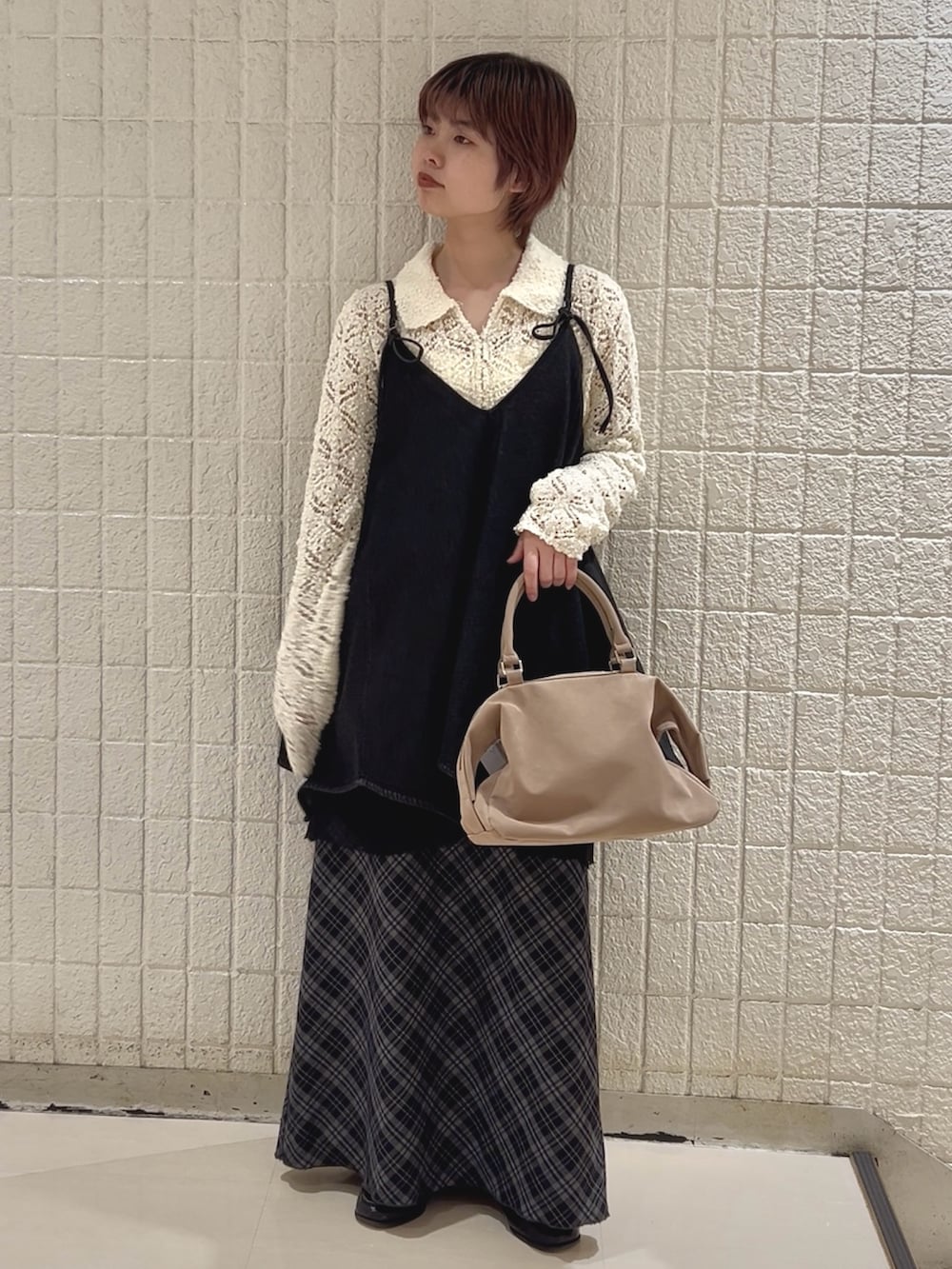 ホワイト系のニット/セーター、ブラック系のワンピース、ブルー系のスカートを着用したレディースの冬コーディネートの2枚目の写真