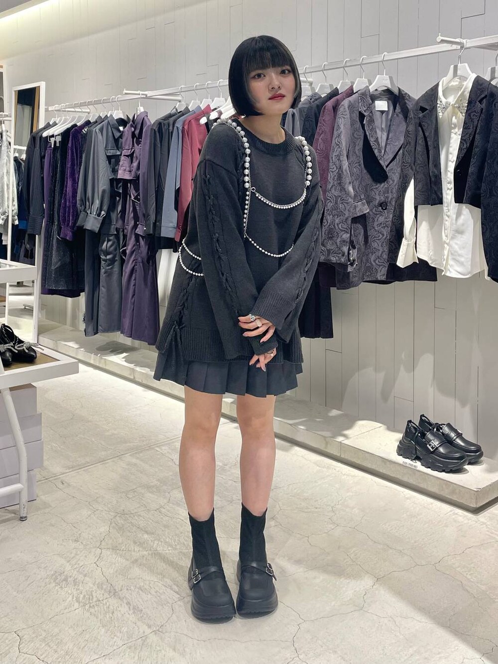 グレー系のテーラードジャケット、ブラック系のブーツ、グレー系のニット/セーターを着用したレディースの秋コーディネートの3枚目の写真