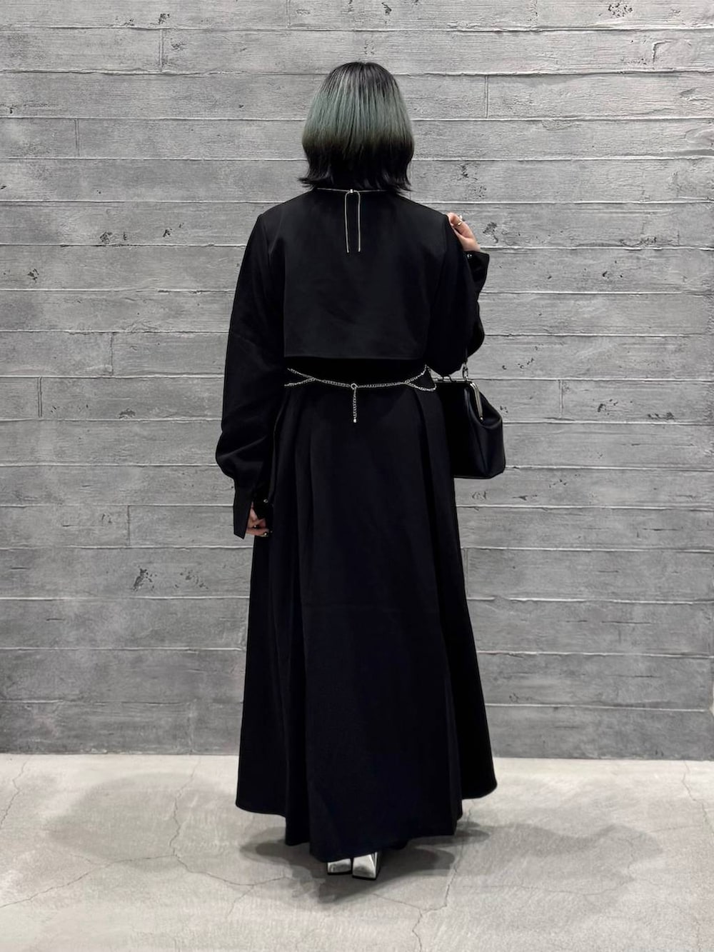 シルバー系のブーツ、ブラック系のワンピース、ブラック系のショルダーバッグを着用したレディースの秋コーディネートの5枚目の写真