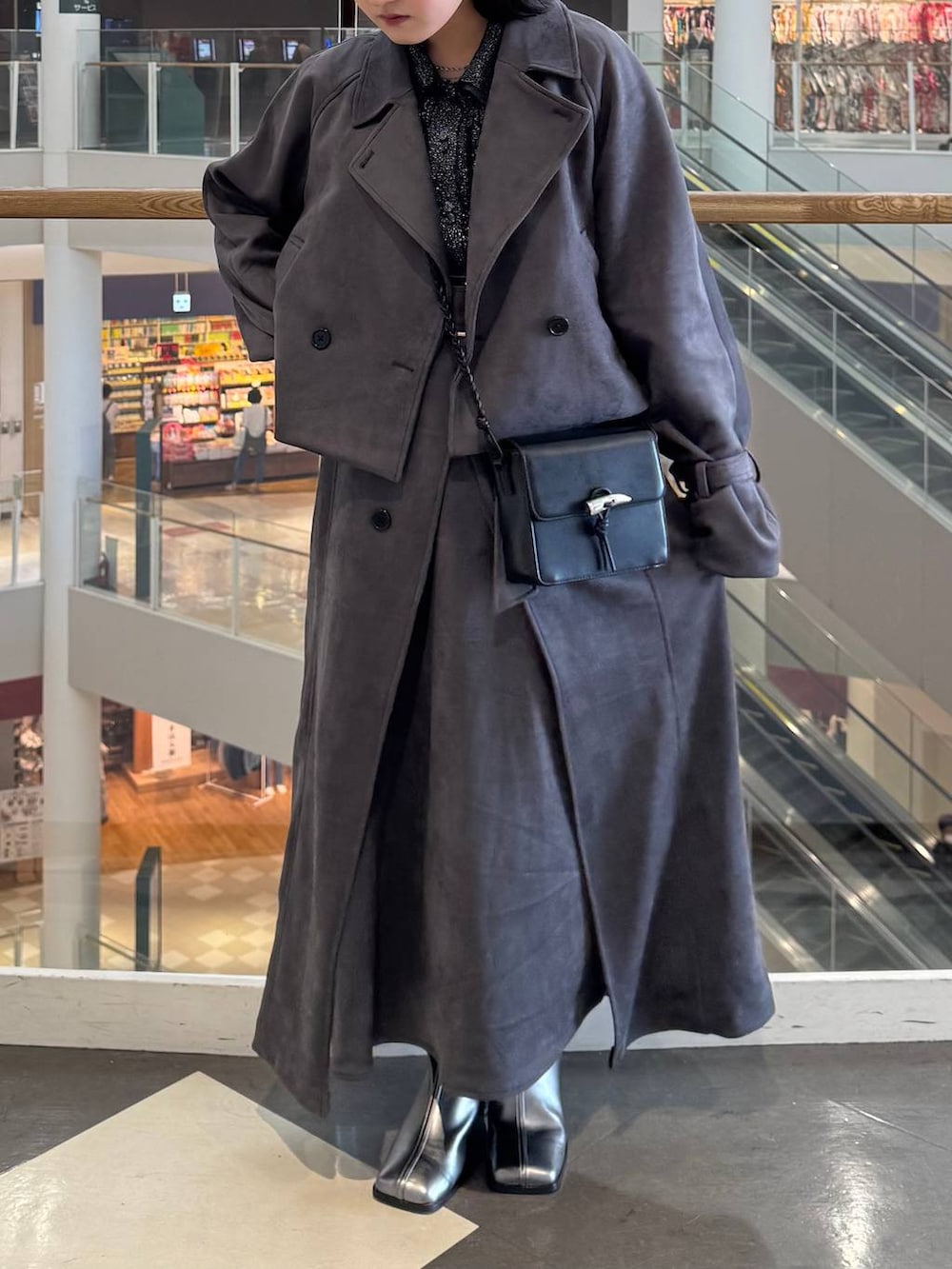 シルバー系のブーツ、ブラック系のショルダーバッグ、ブラック系のカーディガン/ボレロを着用したレディースの秋コーディネートの3枚目の写真