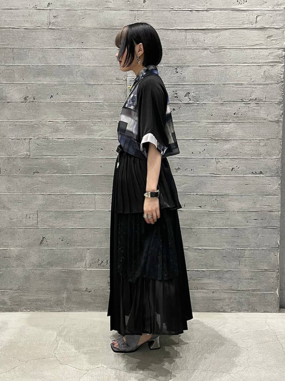 シルバー系のサンダル、ブラック系のスカート、パープル系のシャツ/ブラウスを着用したレディースの春コーディネートの3枚目の写真